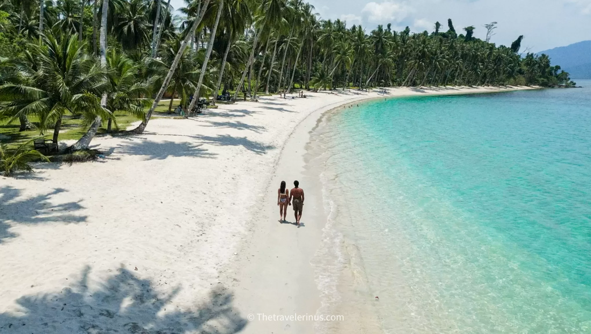 thais and kelvyn walking along white beach port barton